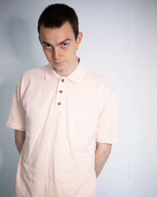 Model wearing pale pink Valentino polo shirt, front view.