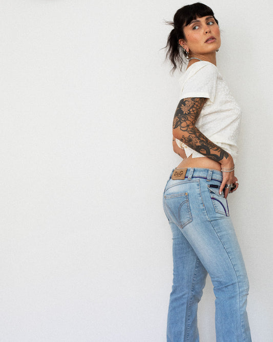 Model wearing Y2K Dolce & Gabbana low-rise flare jeans, side view
