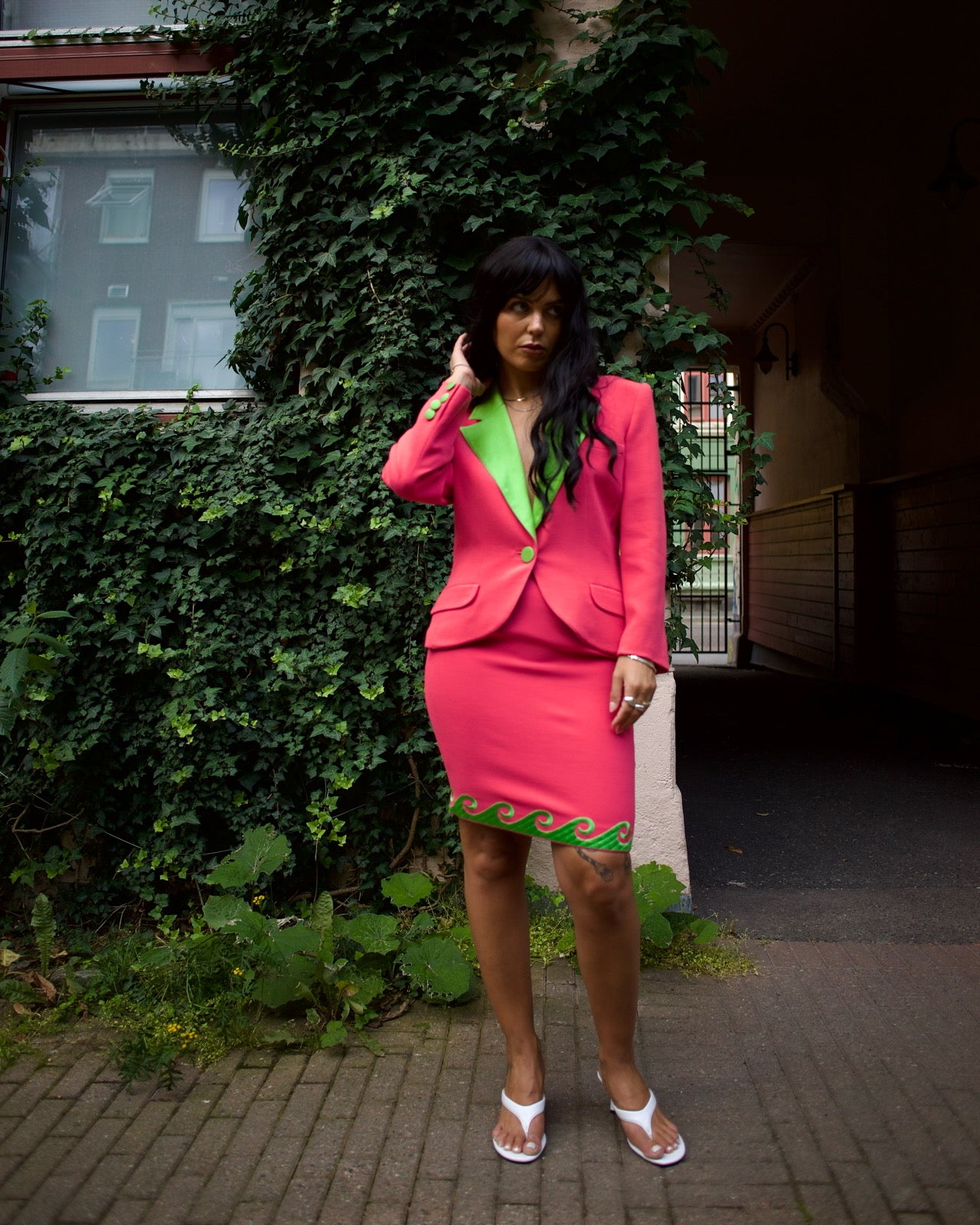 Model wearing the vintage Roccobarocco pink and green skirt suit outdoors