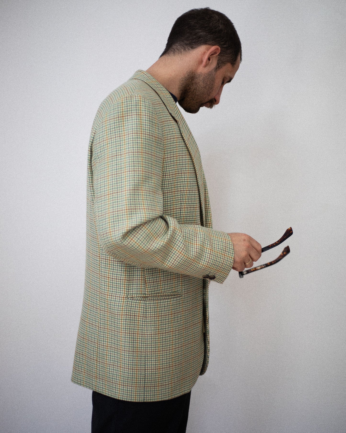 Side view of model wearing green and brown houndstooth blazer