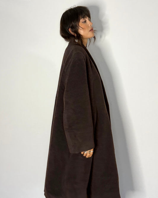 Model side profile wearing oversized Ferré coat with draped fit