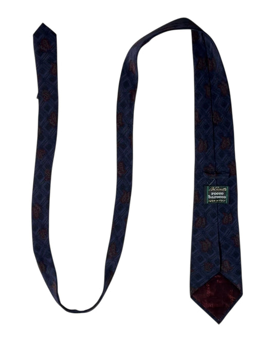 Navy blue patterned tie with a brand label on a white background