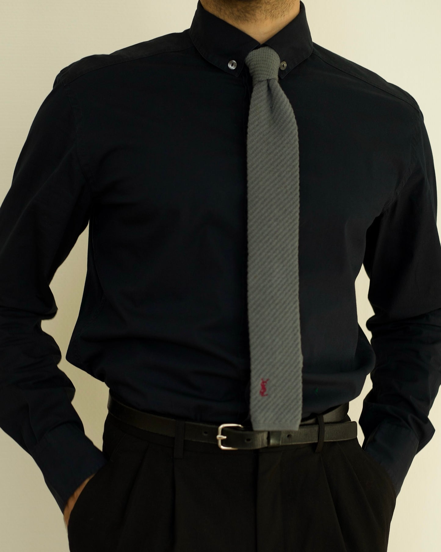 Model wearing YSL tie styled with black shirt and belt.