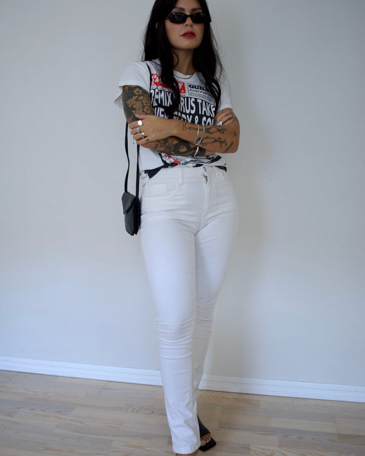 Model wearing Valentino white jeans with printed top and heels