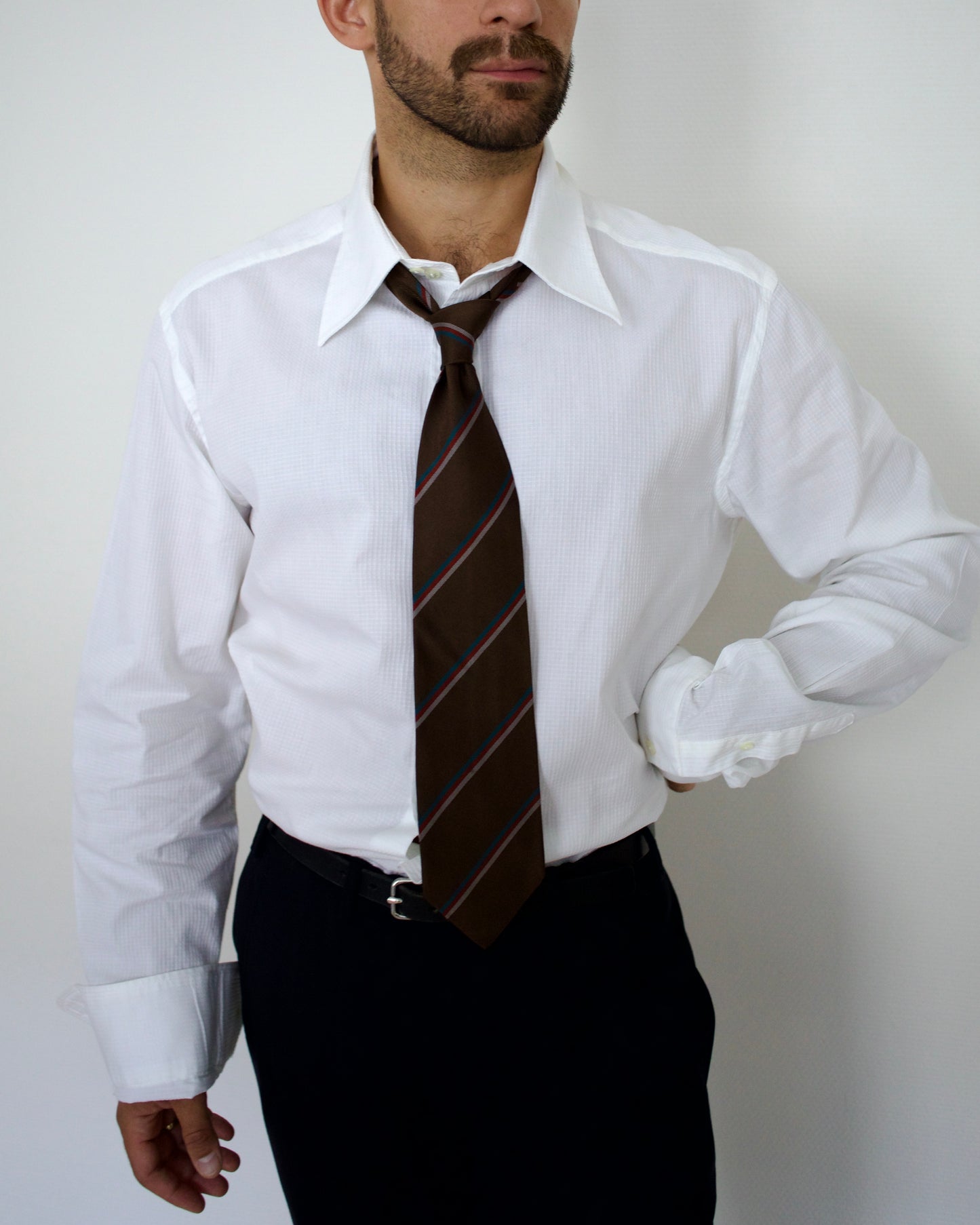 Dolce & Gabbana white dress shirt with a brown striped tie against a plain background