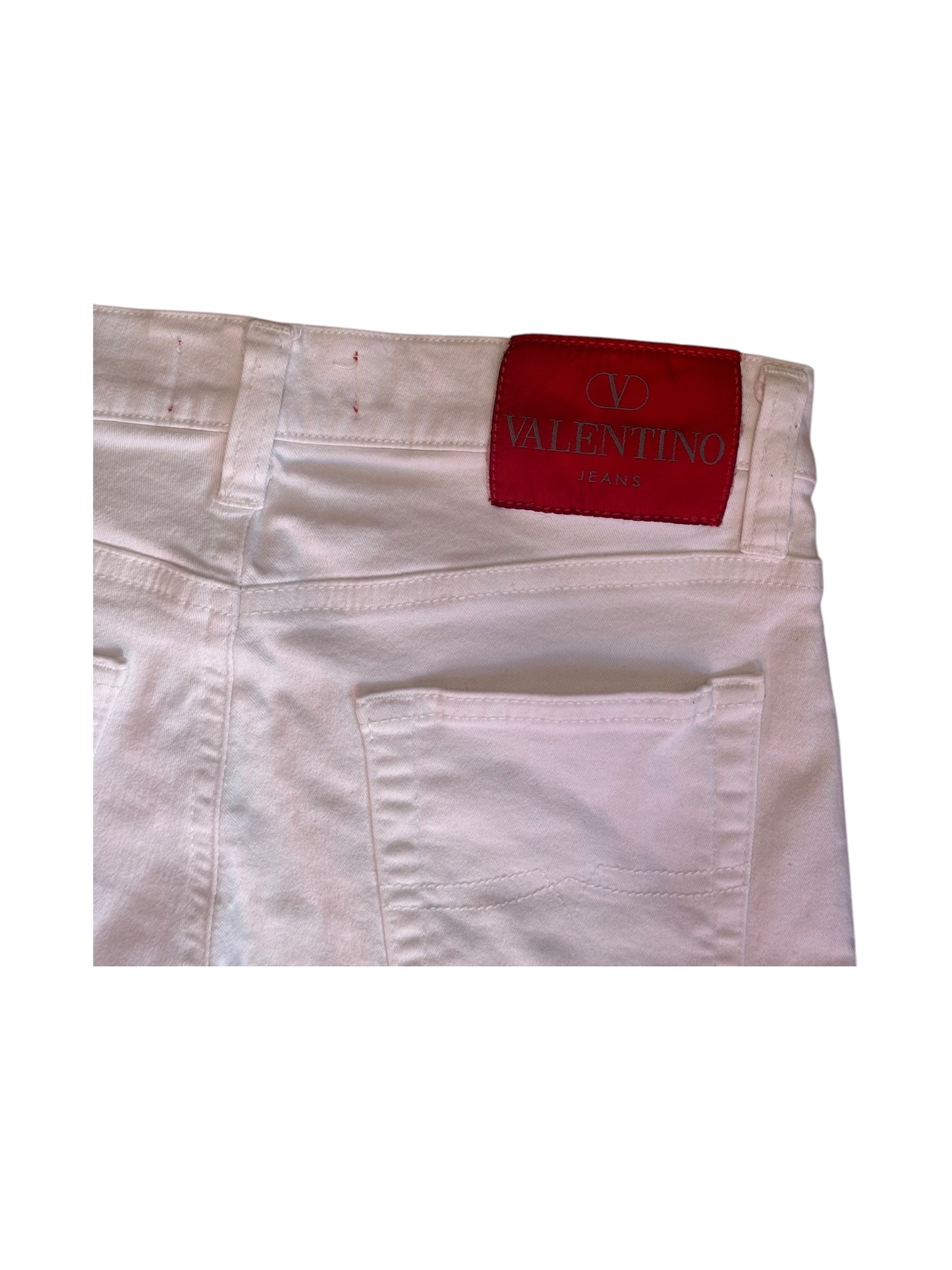 Close-up of red Valentino leather logo patch on ivory denim