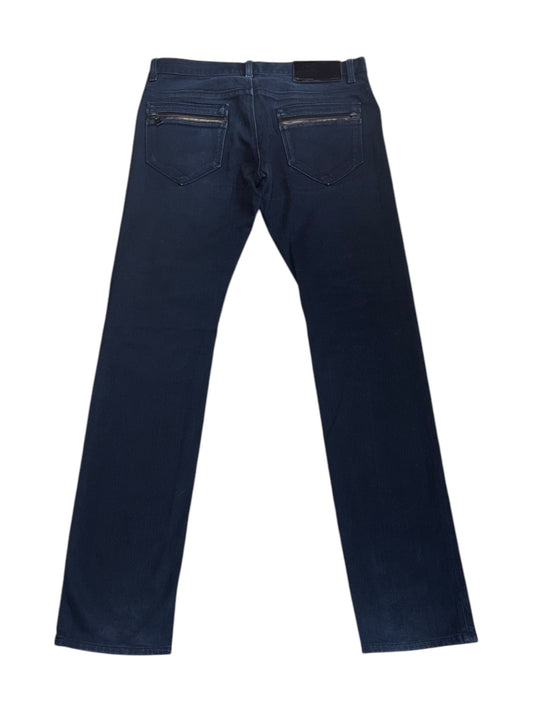 A pair of Prada slim-fit tapered jeans in a faded indigo wash with signature zippered back pockets and subtle branding.