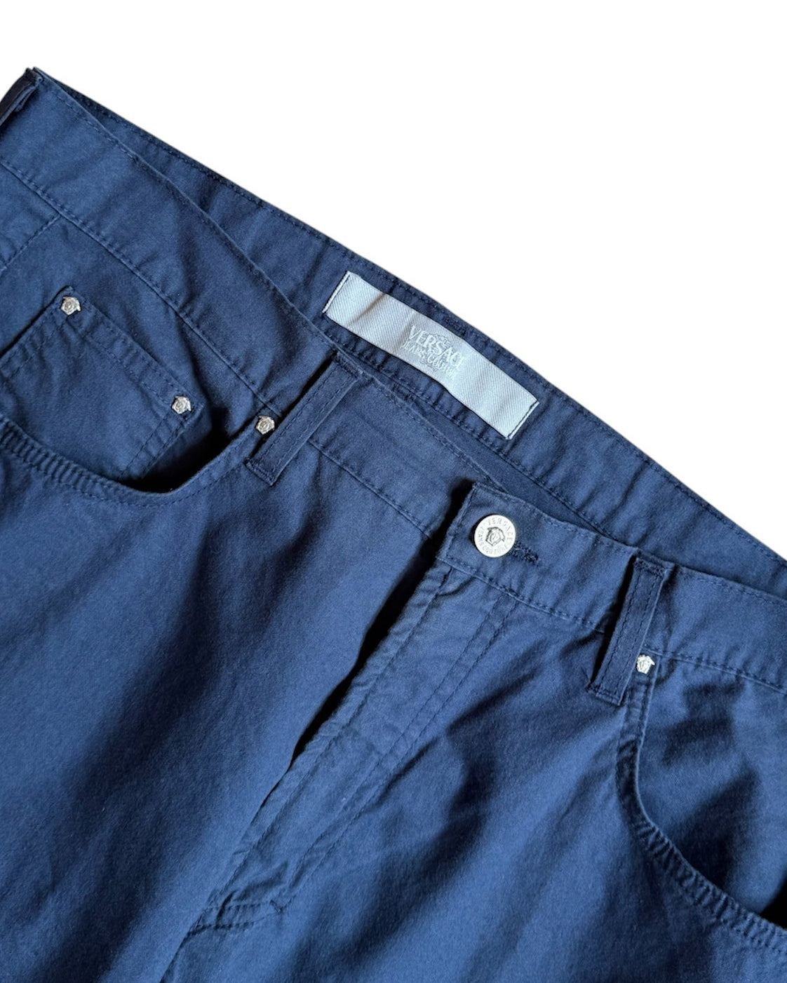 Close-up of waistband and Versace Jeans Couture logo tag on navy vintage cotton chinos