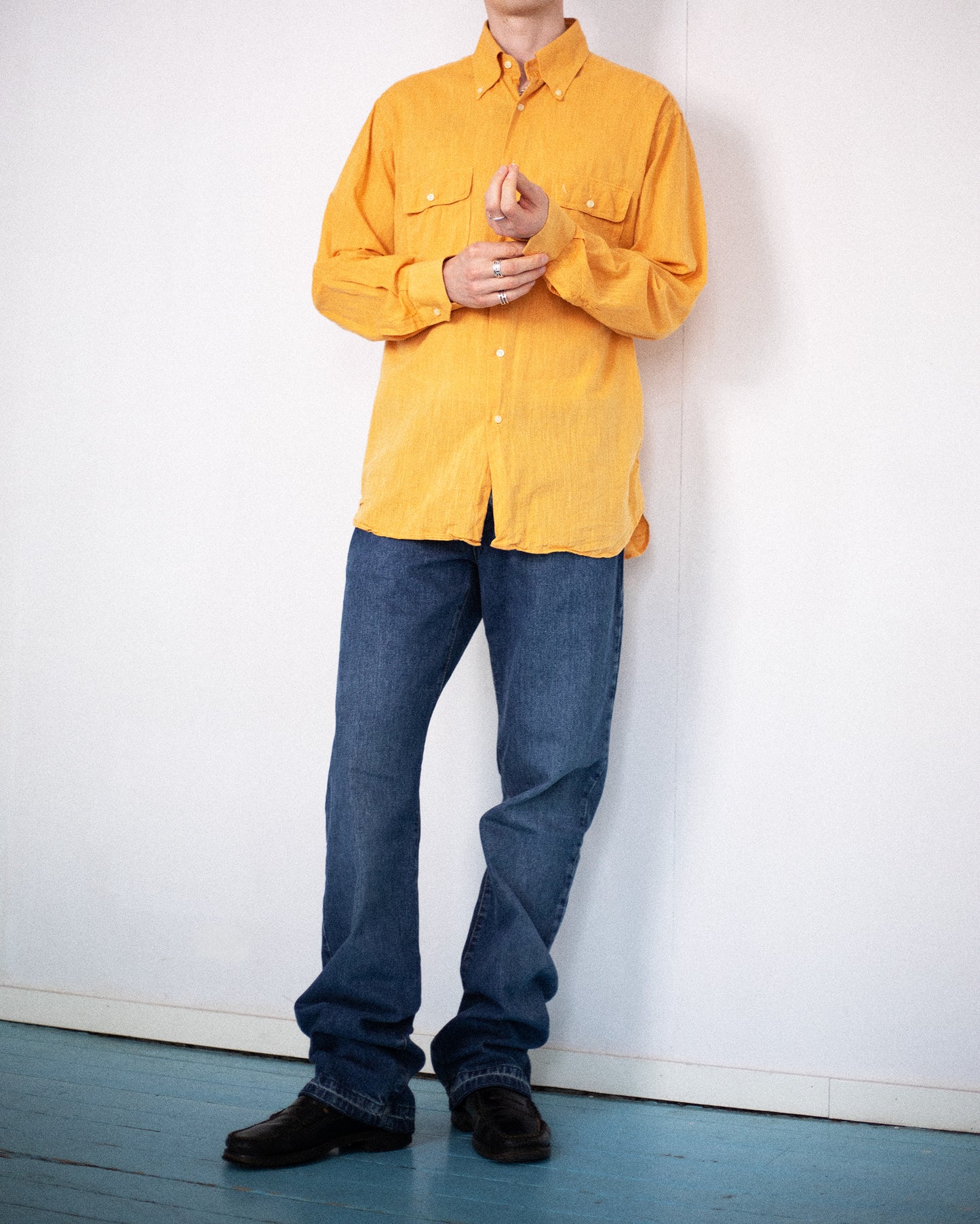 Model wearing D&G jeans styled with yellow shirt and black shoes.