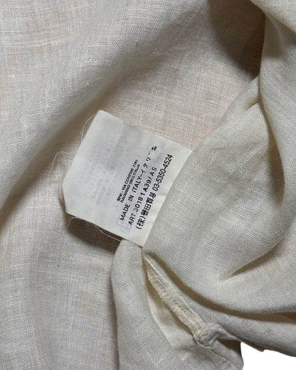Close-up of a light beige or off-white woven fabric with a sewn-in white product CP Company tag