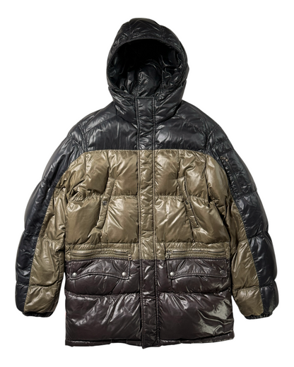 A color-blocked Prada puffer jacket with a shiny black hood and upper body, olive green middle section, and dark brown lower section, shown against a plain white background.