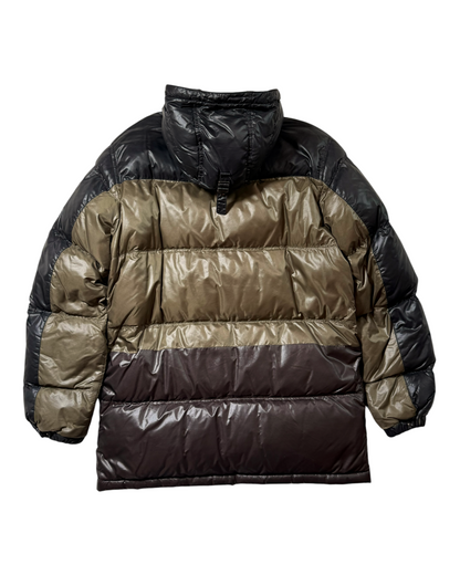 A Prada puffer jacket with a color-blocked design featuring horizontal stripes of black, olive green, and dark brown, shown from the back on a white background.